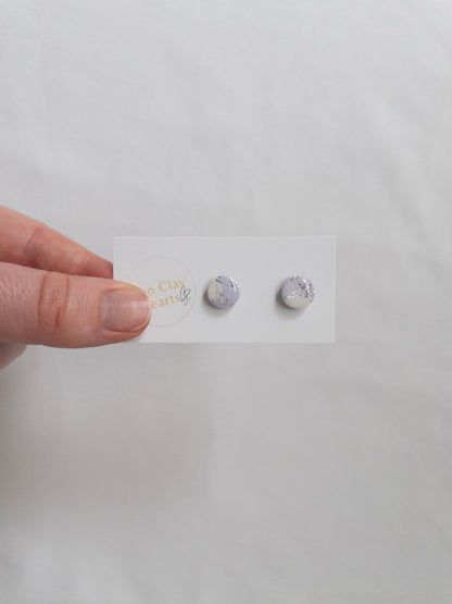 Mini purple and silver circle stud earrings on white backing card