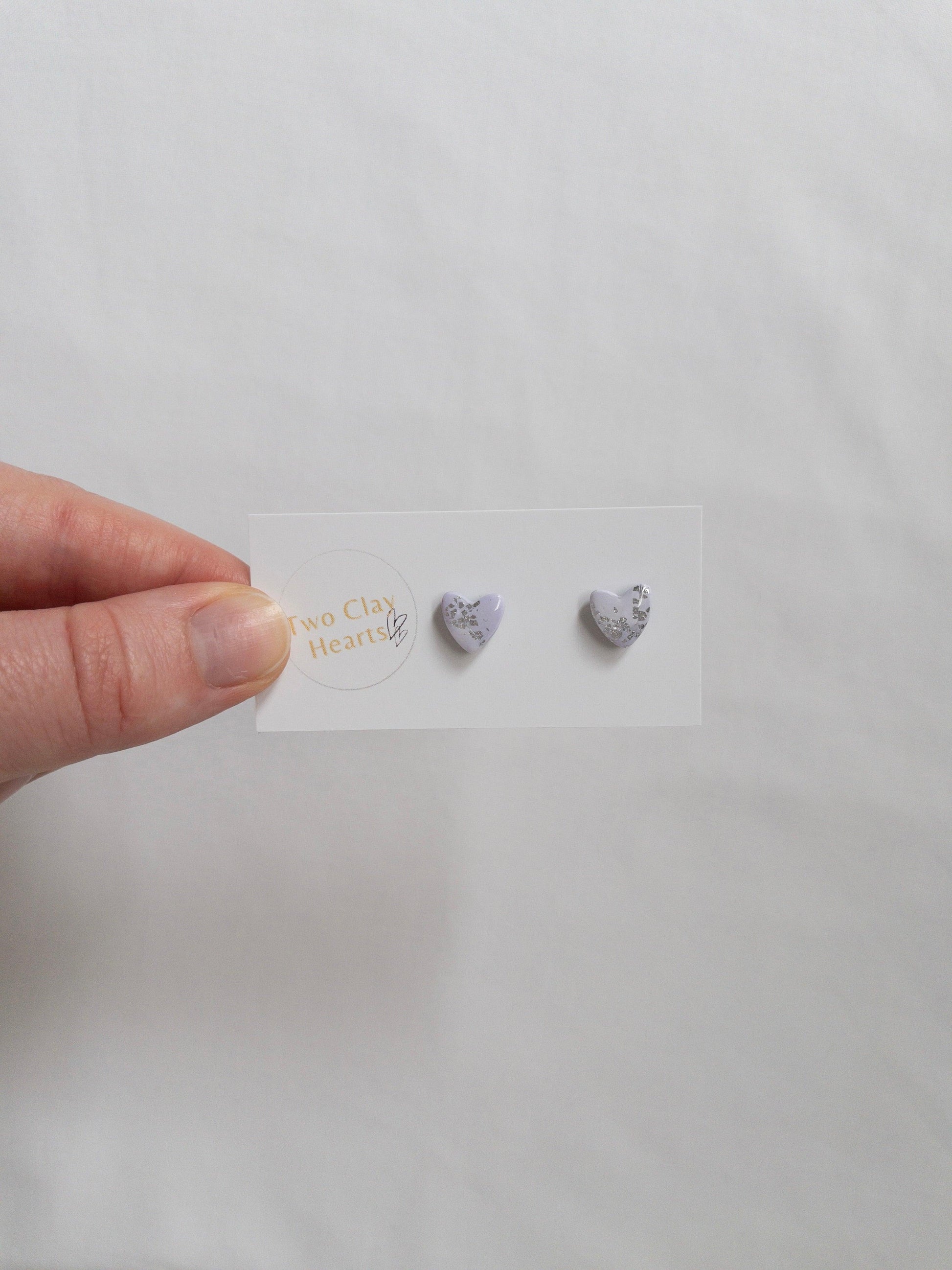 Mini purple and silver heart stud earrings on white card