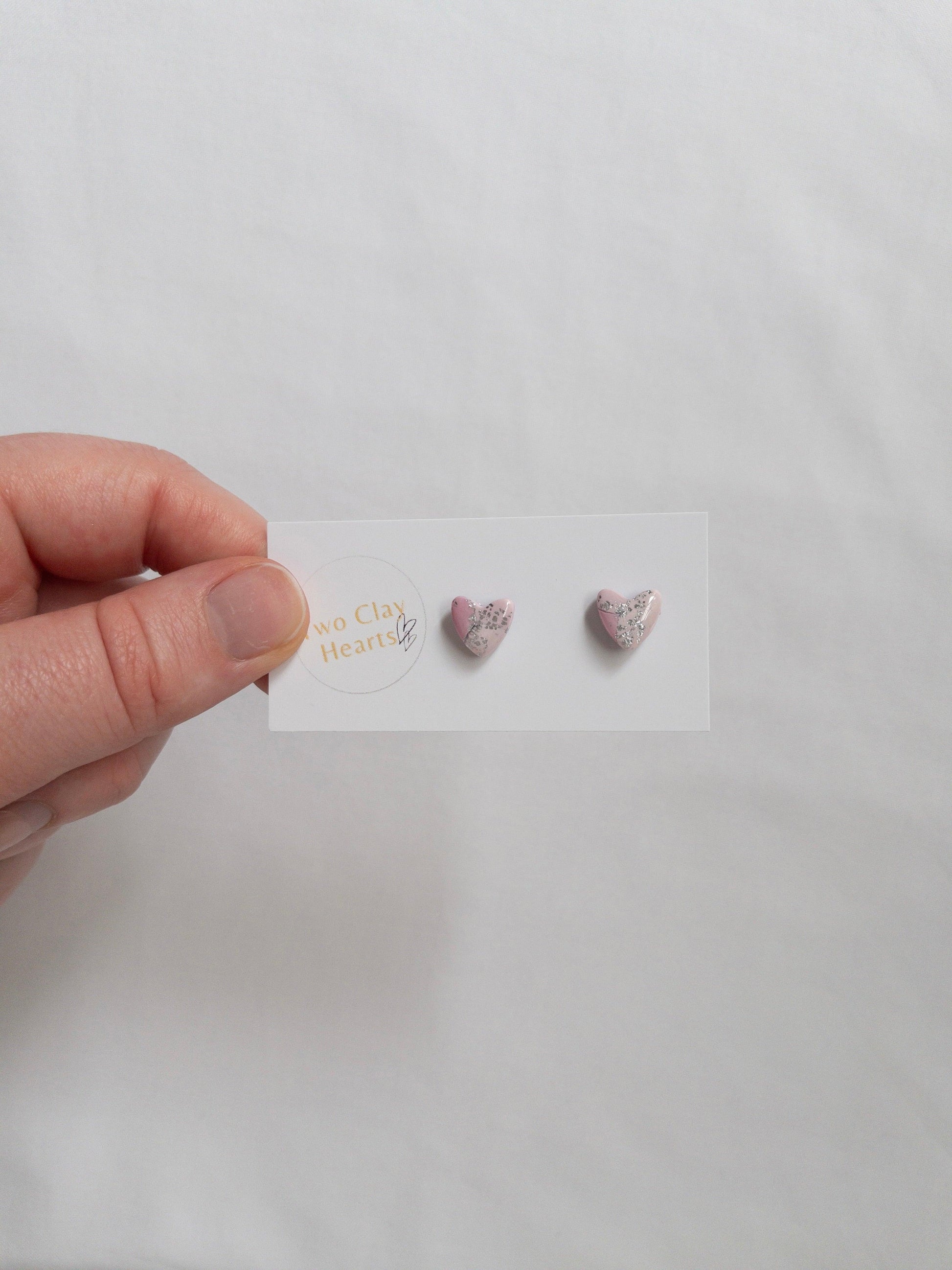 Mini pink and silver heart stud earrings on white card