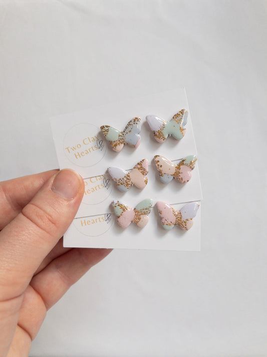 three pairs of pastel multicoloured butterfly studs earrings with gold flecks