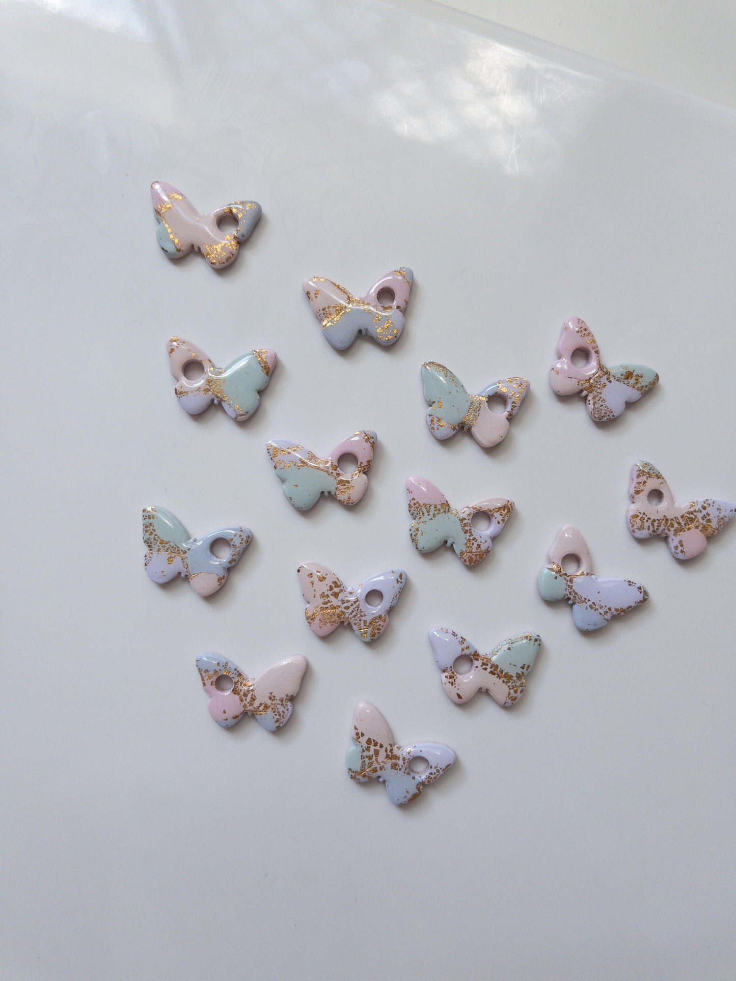 rainbow pastel coloured butterfly earring pieces on a white background