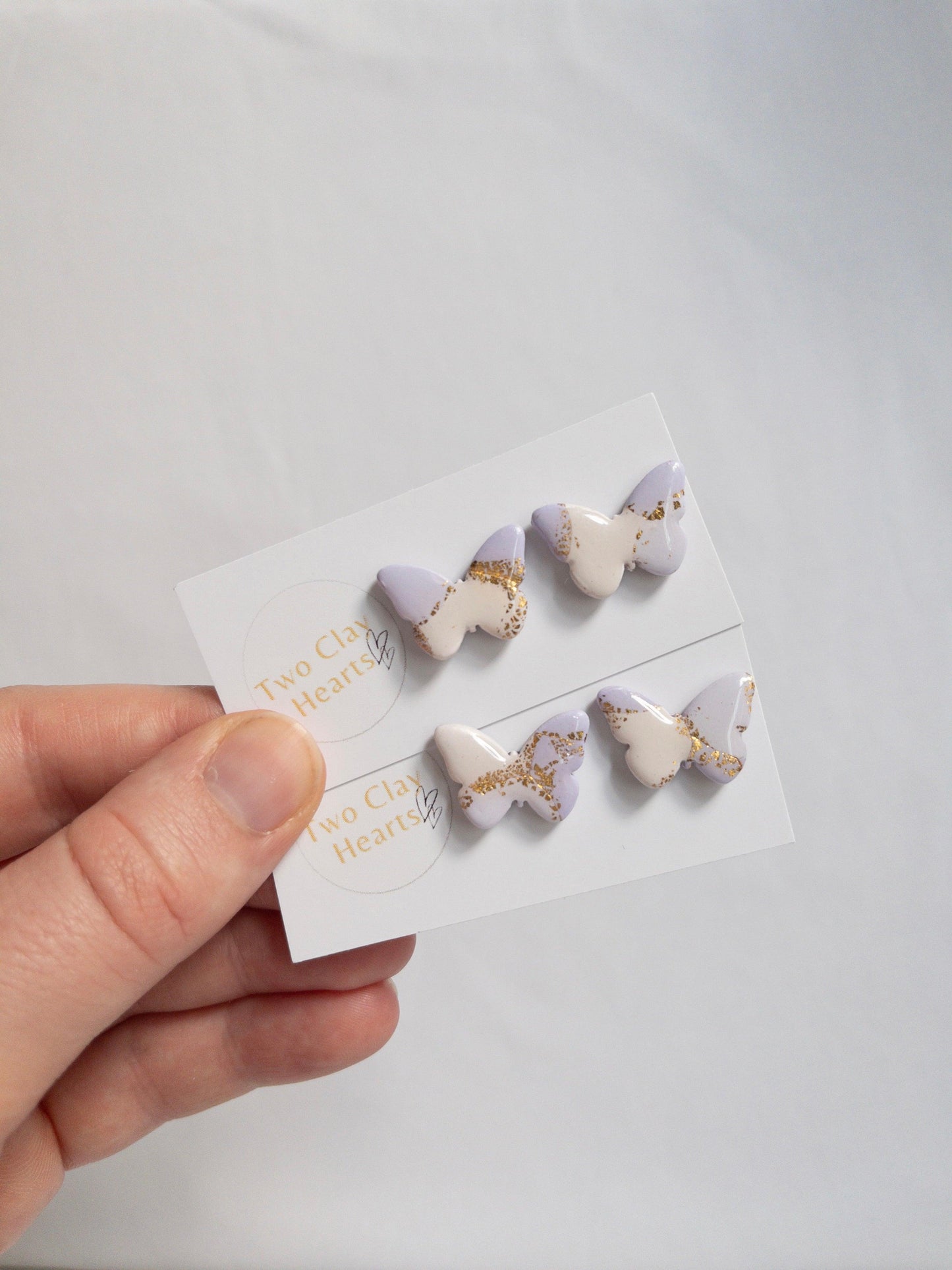 purple and white butterfly stud earrings with gold flecks