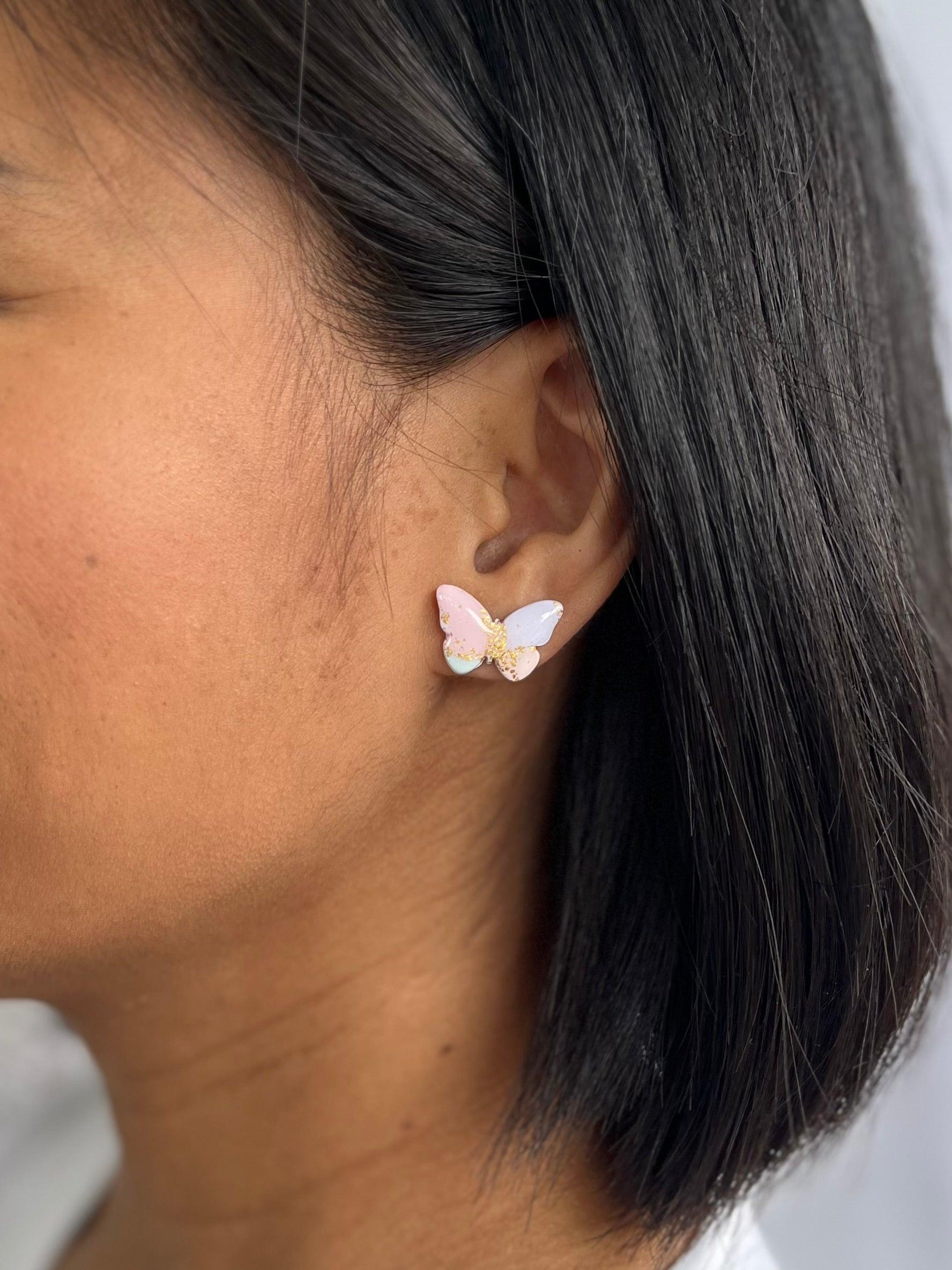 Pastel Butterfly stud earrings on models ear