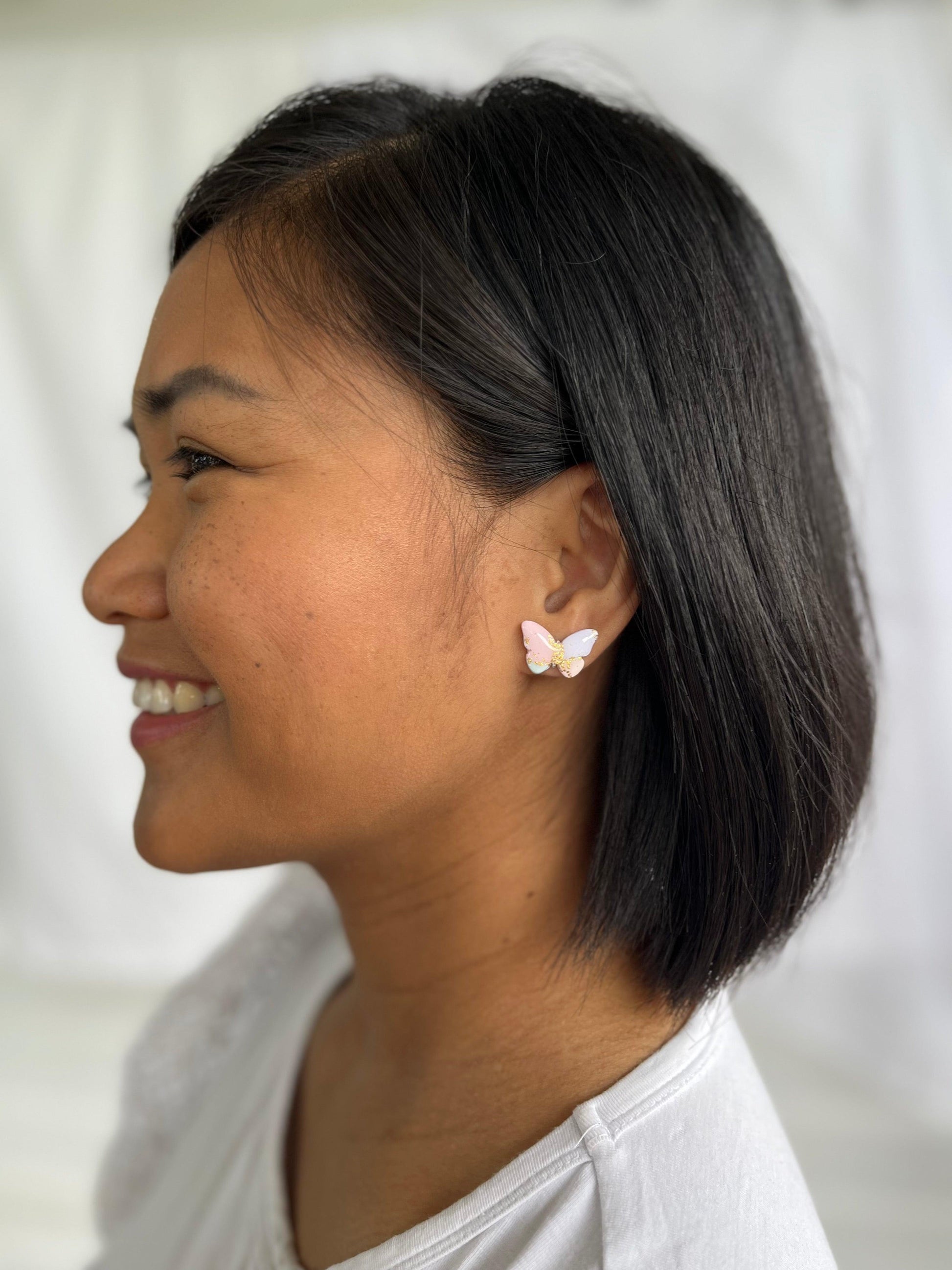 Pastel Butterfly stud earrings on models ear