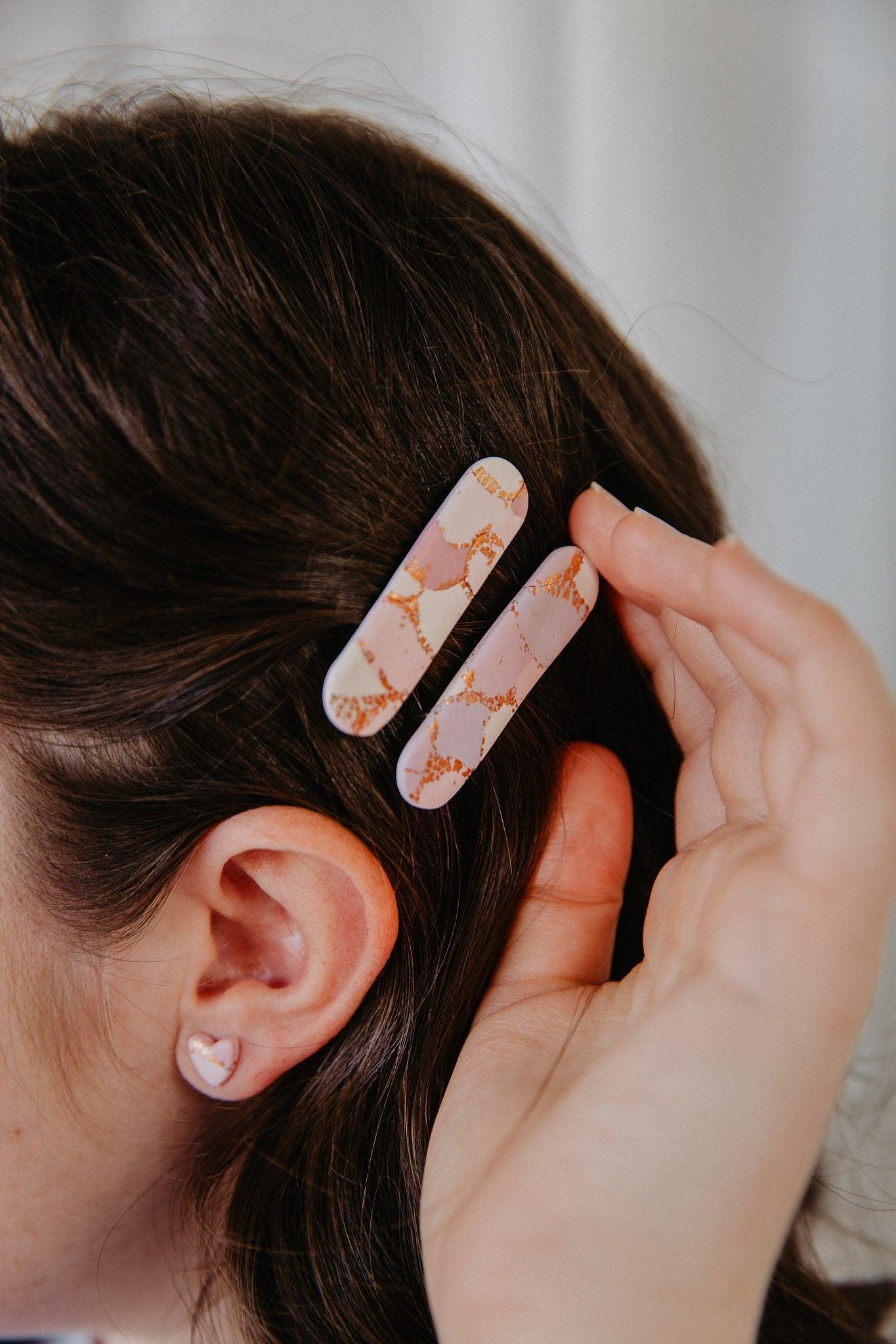 a set of two oblong polymer clay hair clips in a models hair