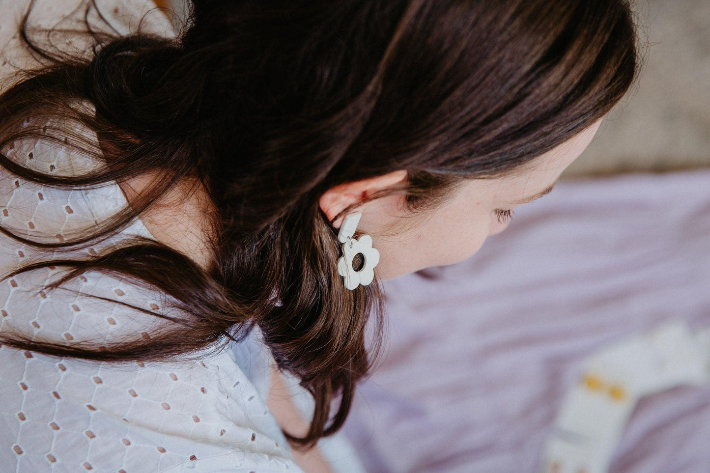 a pair of pastel flower shaped dangles worn on a model