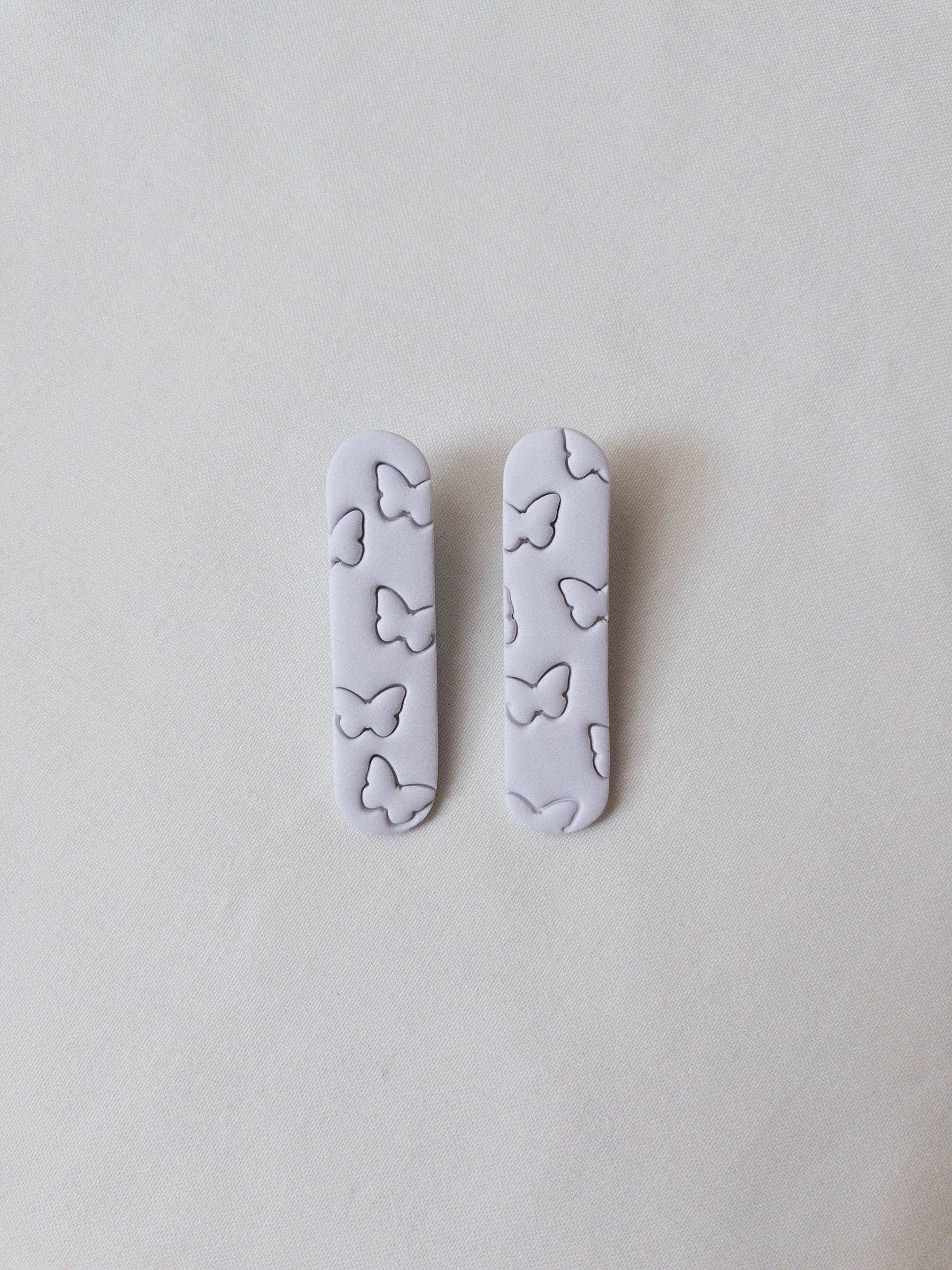 a set of two pastel purple butterfly printed hair clips on a white background