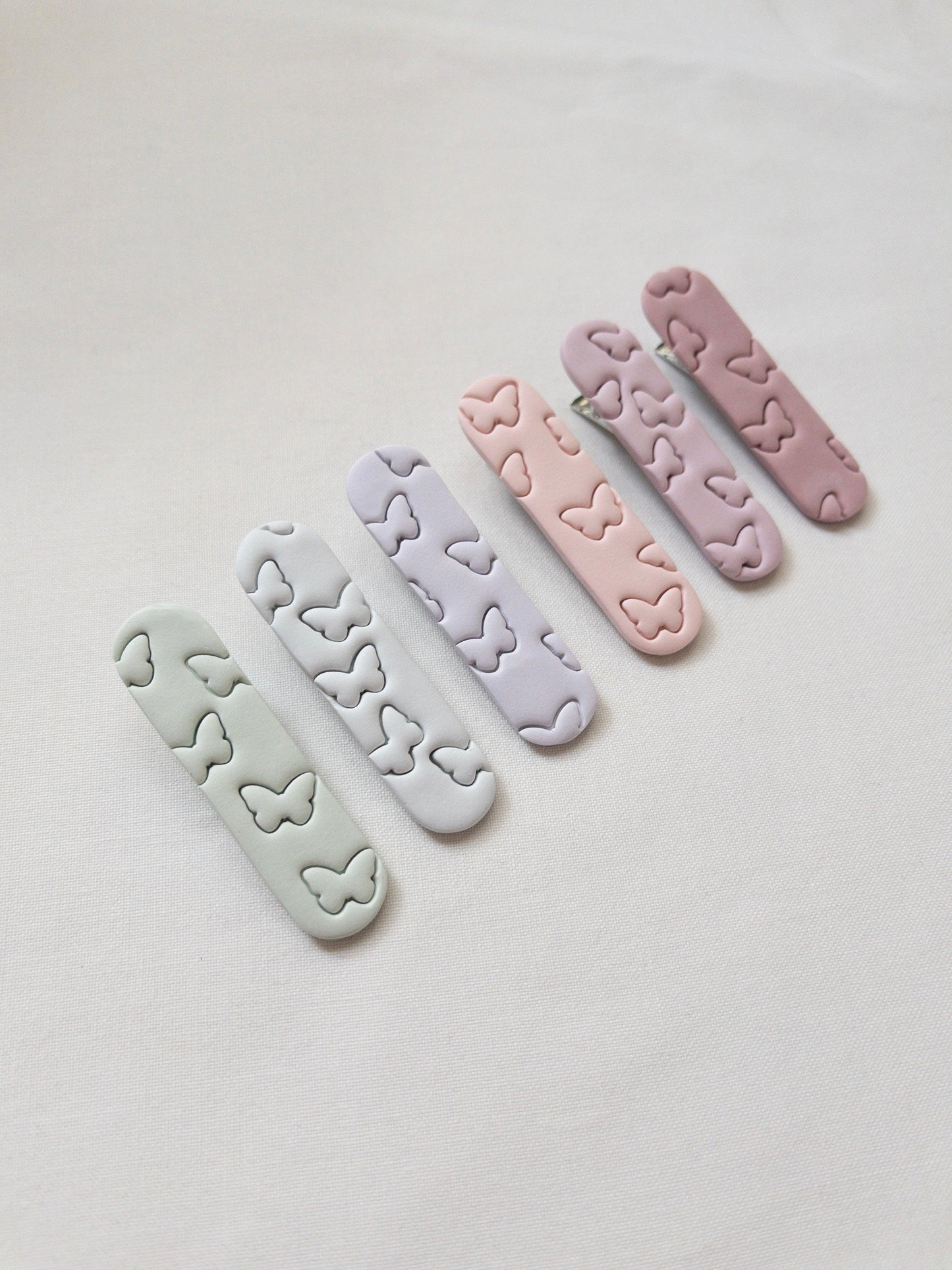 a range of pastel butterfly printed hair clips on a white background