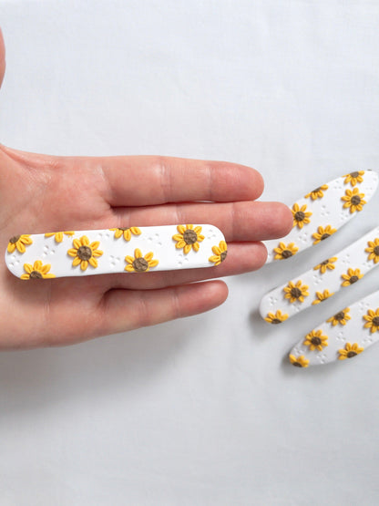 Long sunflower hair barrette held in someones hand 