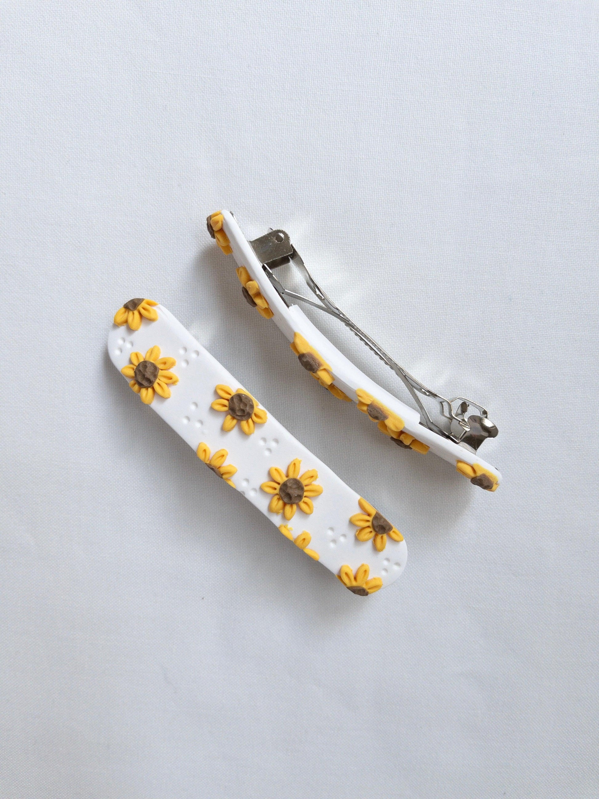 Close up showing polymer clay, sunflower hair clip with stainless steel hair barrette