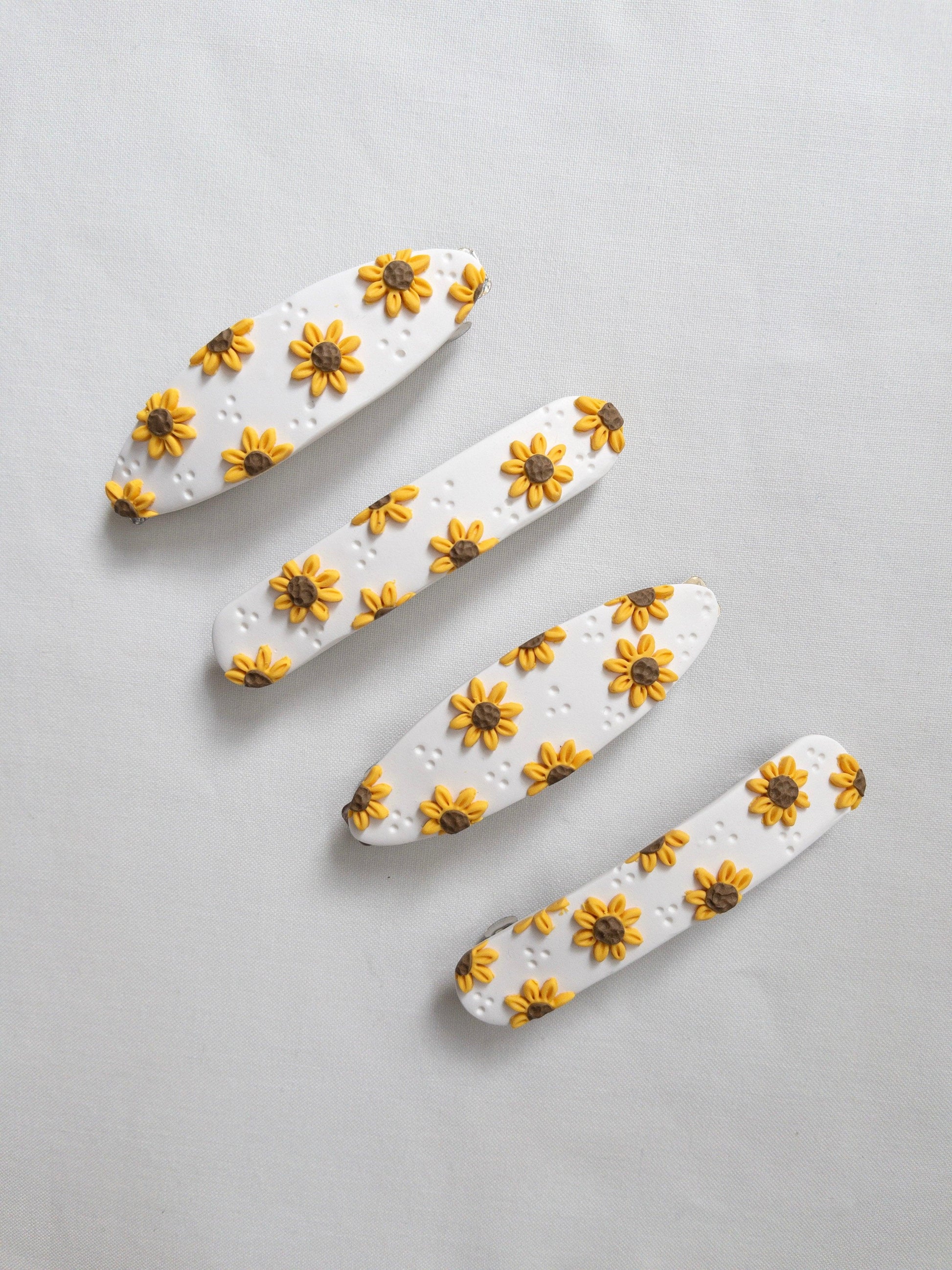 A range of sunflower hair clips on a white background