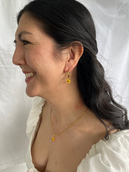 Gold and beaded sunflower necklace and hoops on model