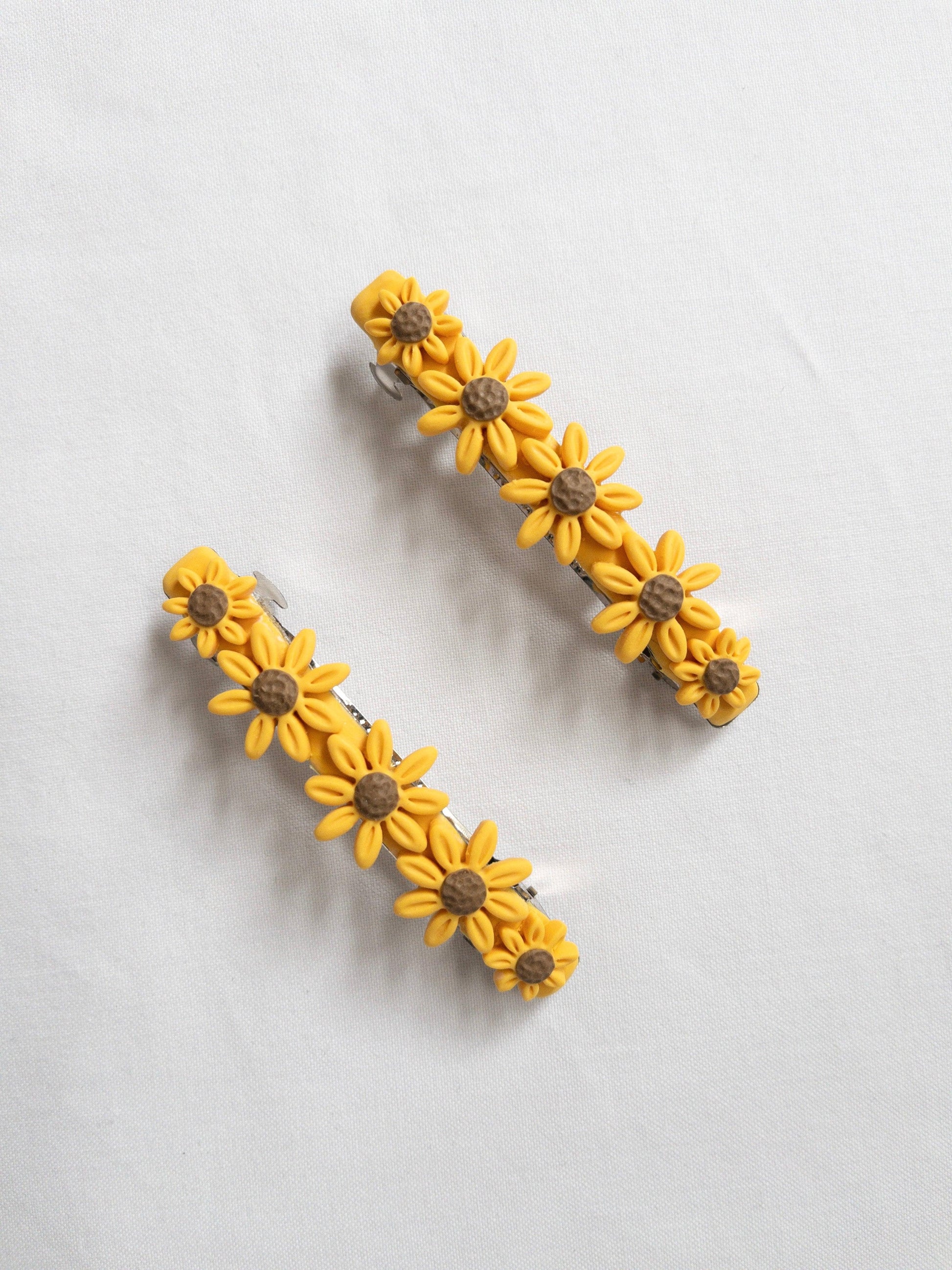 Polymer clay sunflower shaped, hair barrettes on white background