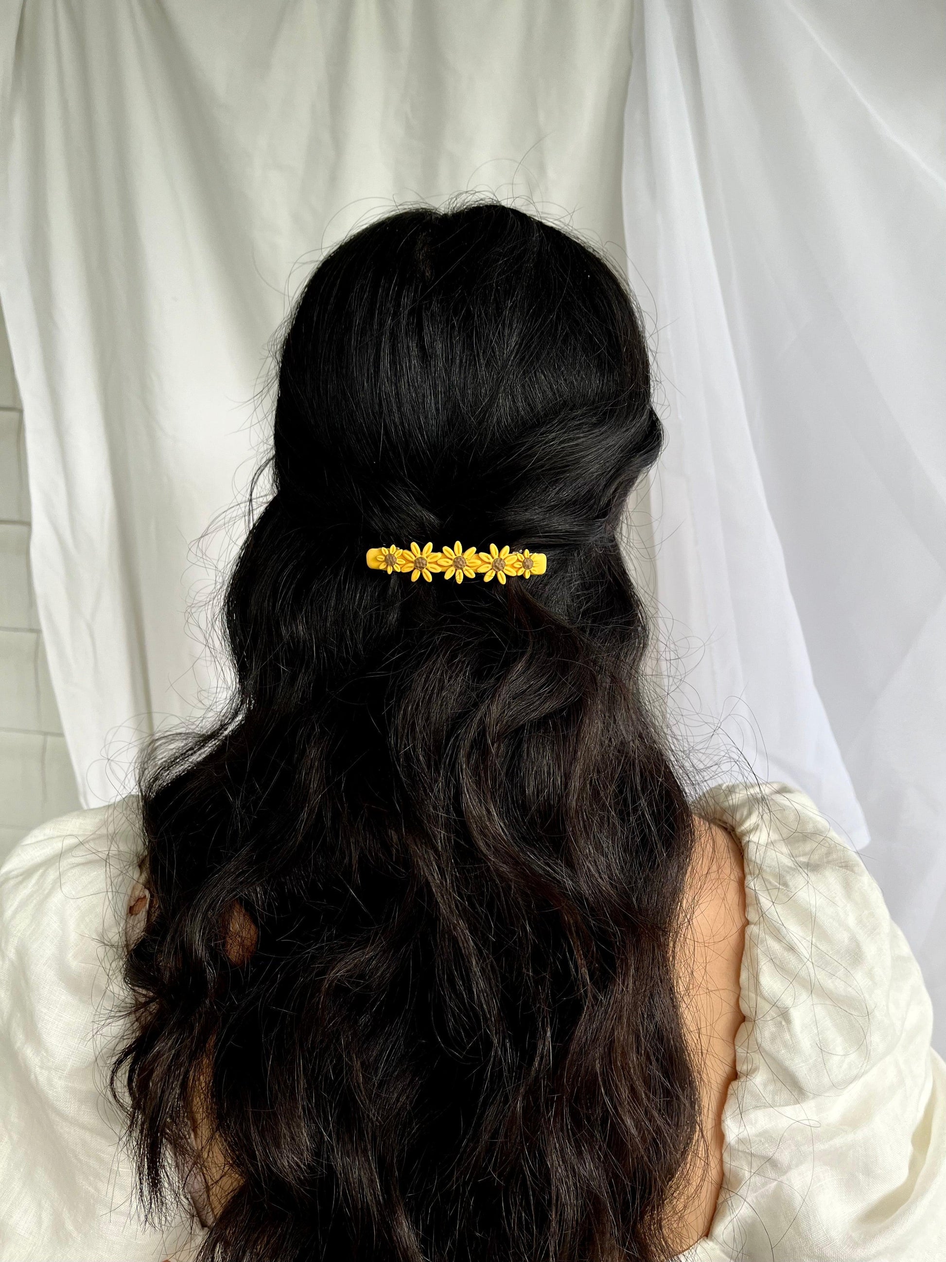 Yellow flower hair barrette on models hair