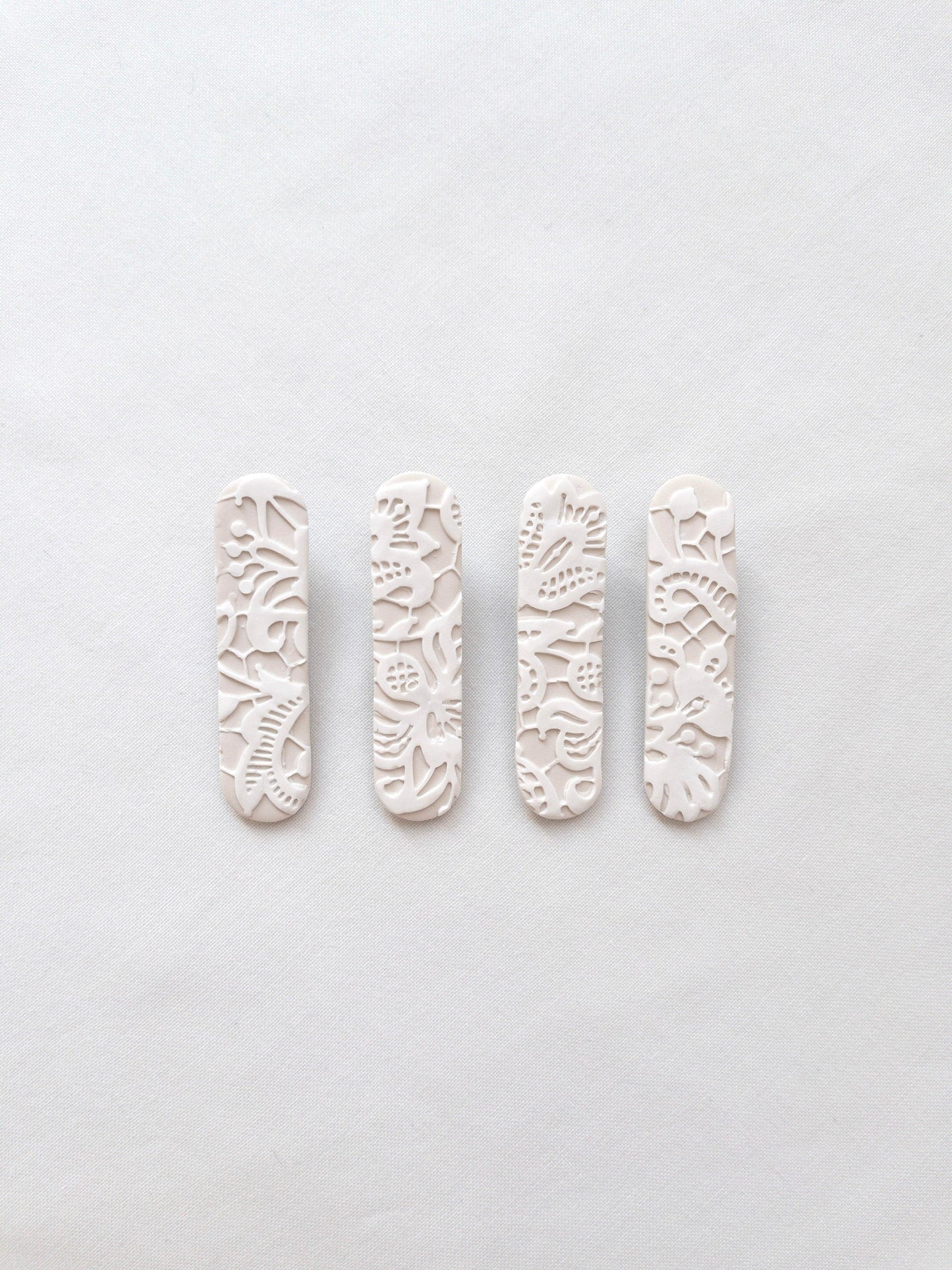 White lace patterned polymer clay hair clips on white backdrop