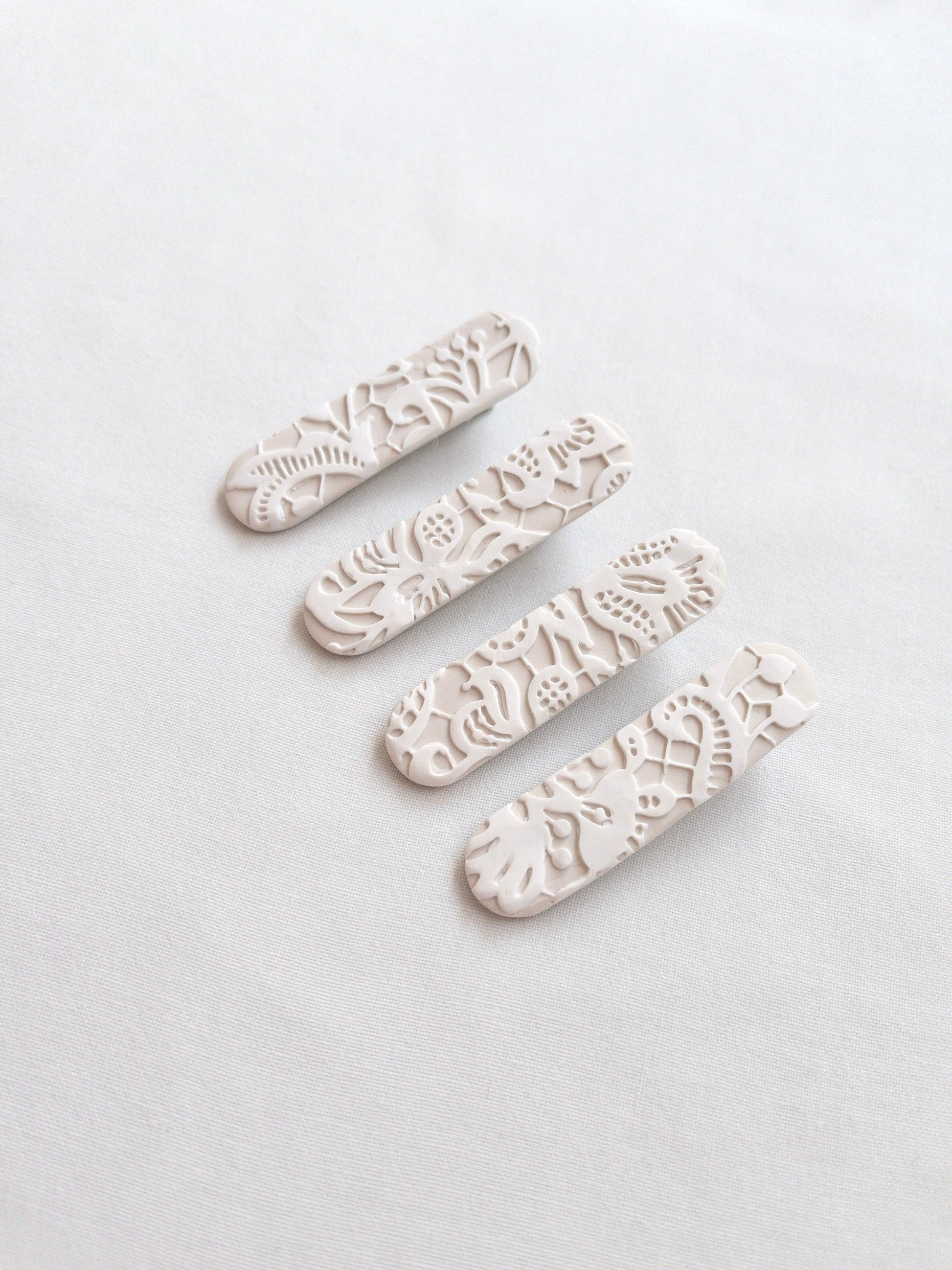 White lace patterned polymer clay hair clips on white backdrop