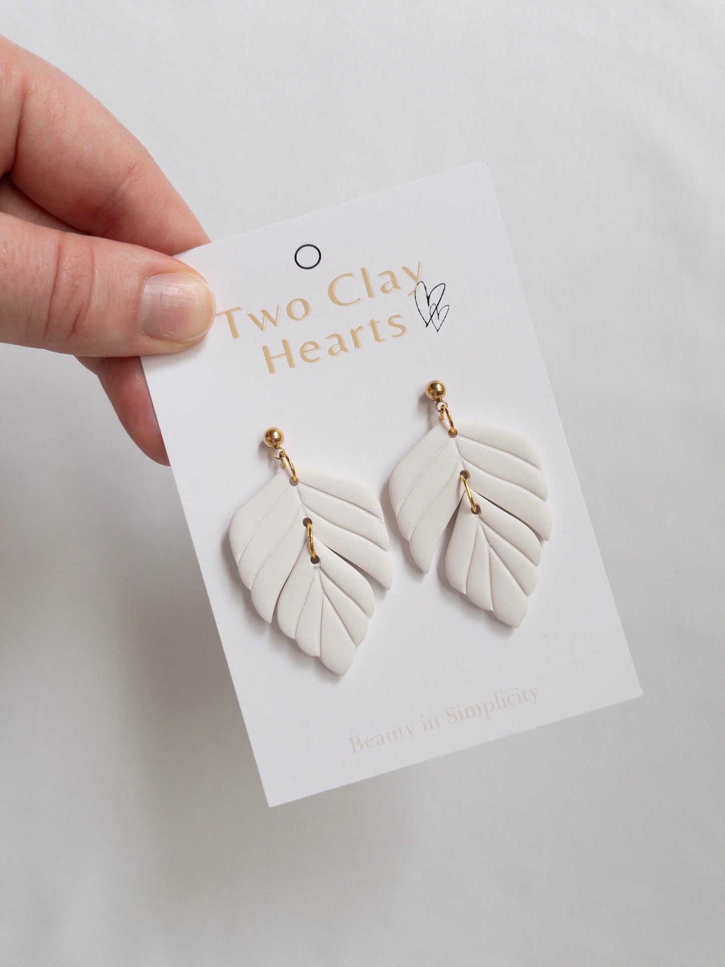 White polymer clay statement earrings on white backing card