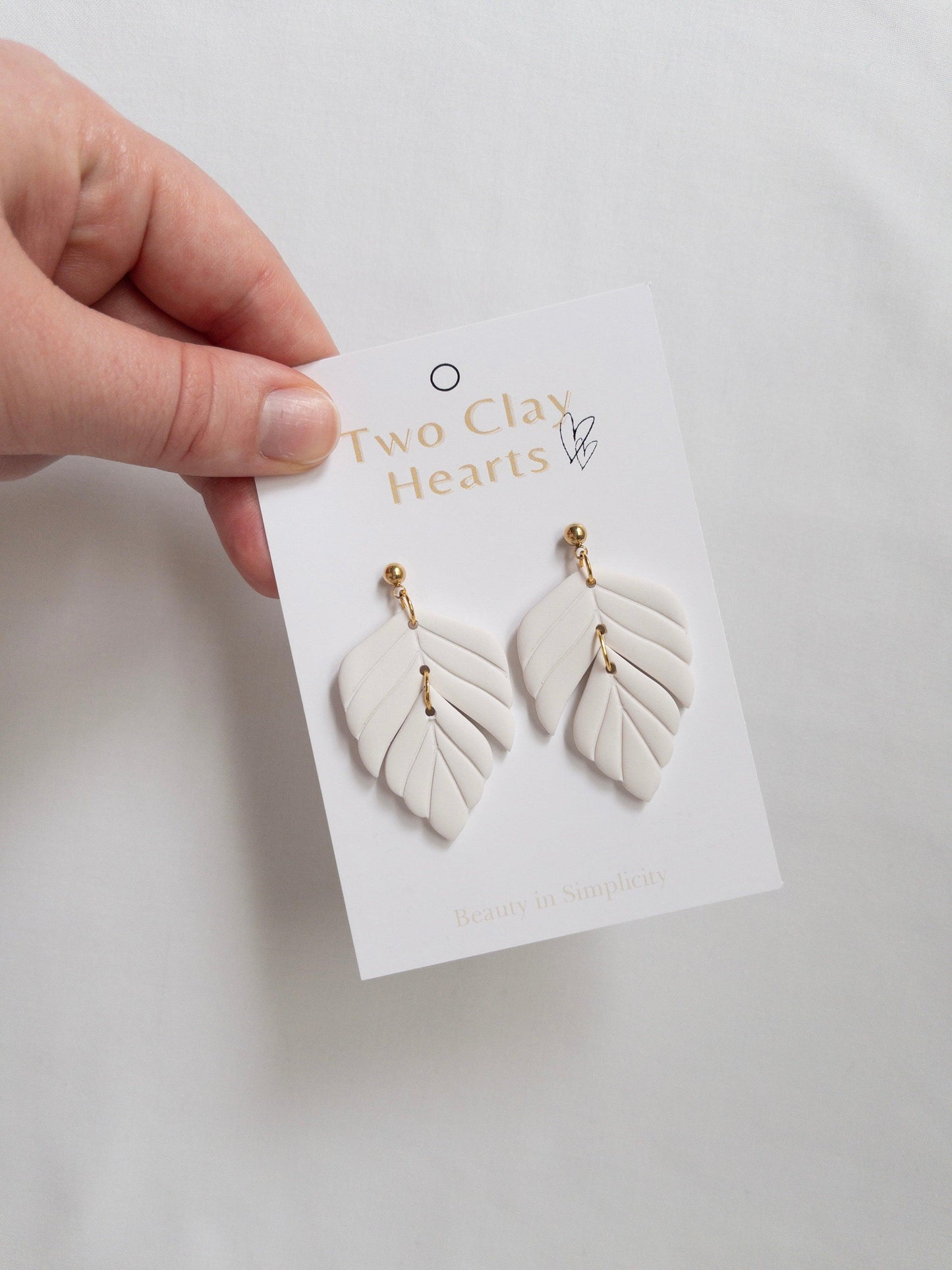 White polymer clay statement earrings on white backing card