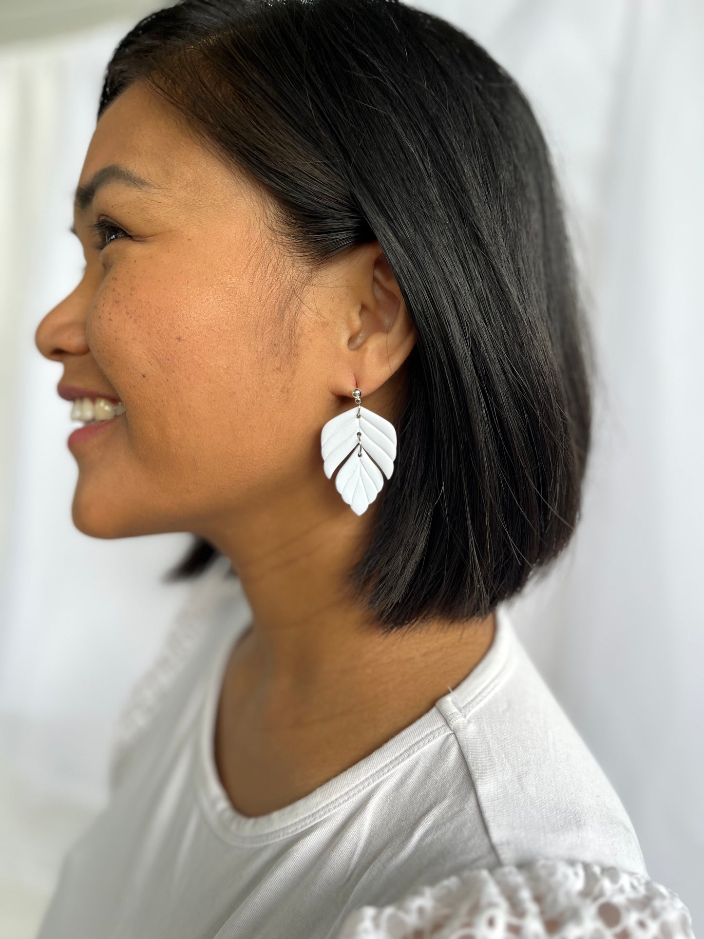 White polymer clay statement earrings on models ear